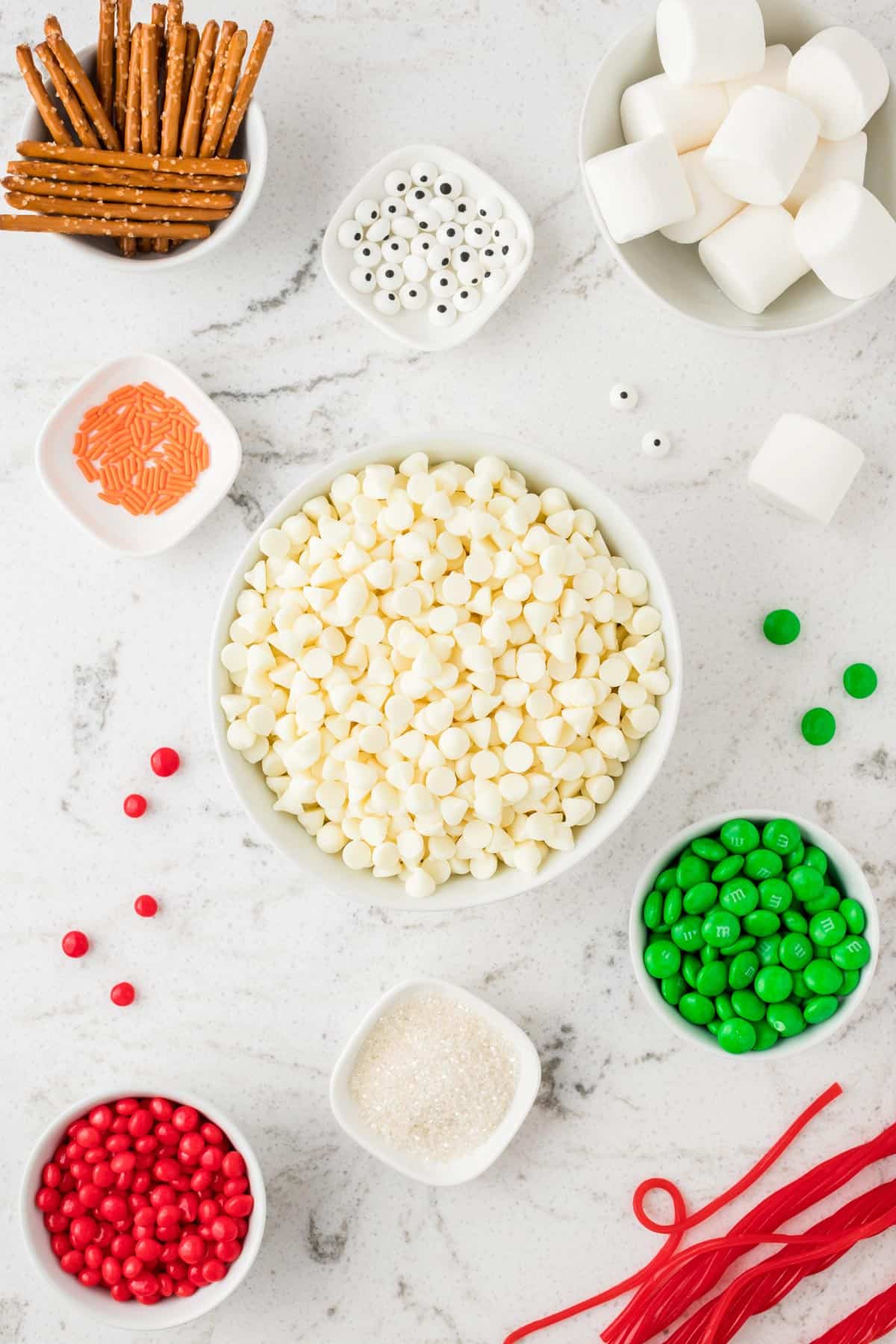 ingredients to make snowman bark in white bowls on white background