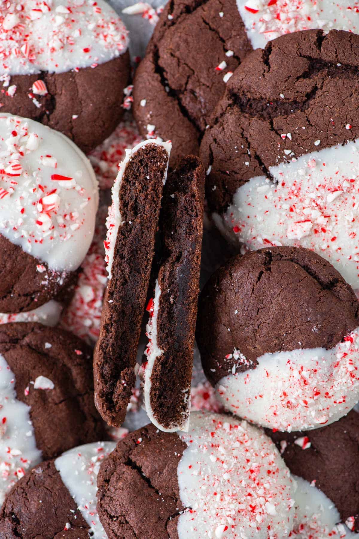 A candy cane chocolate cookie cut in half on top of other cookies