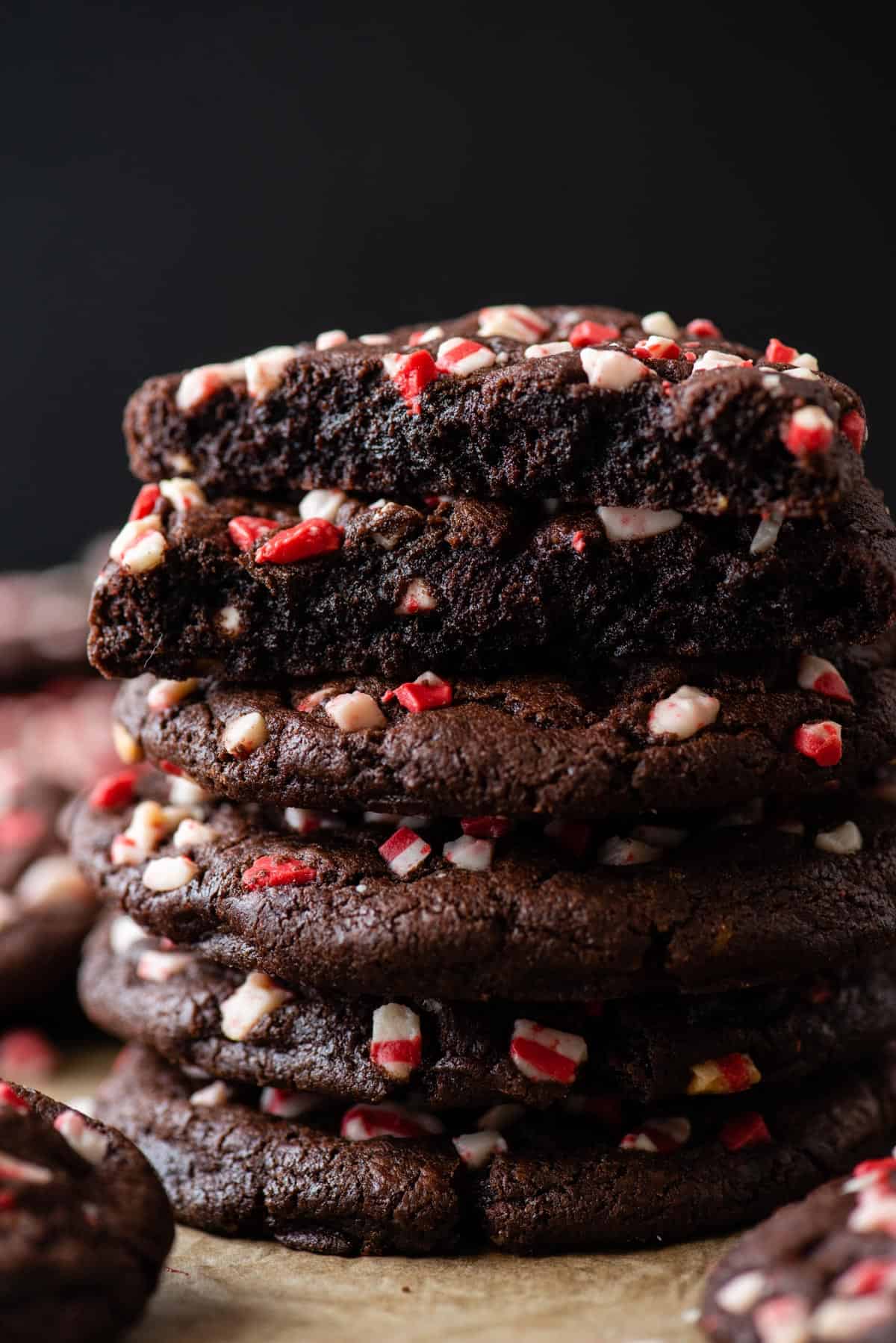 A stack of chocolate peppermint cookies, the top one cut in half