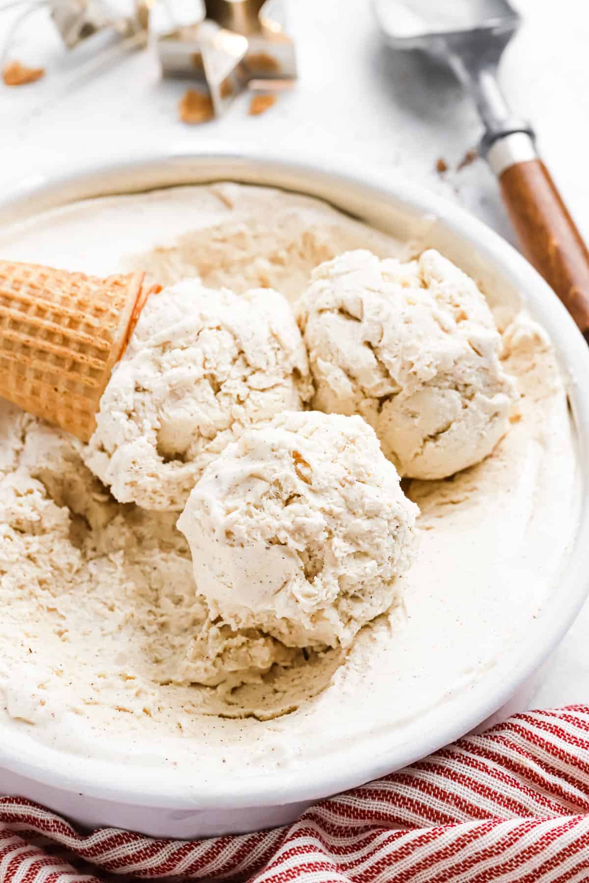 Three scoops of eggnog ice cream and a waffle cone on the pan