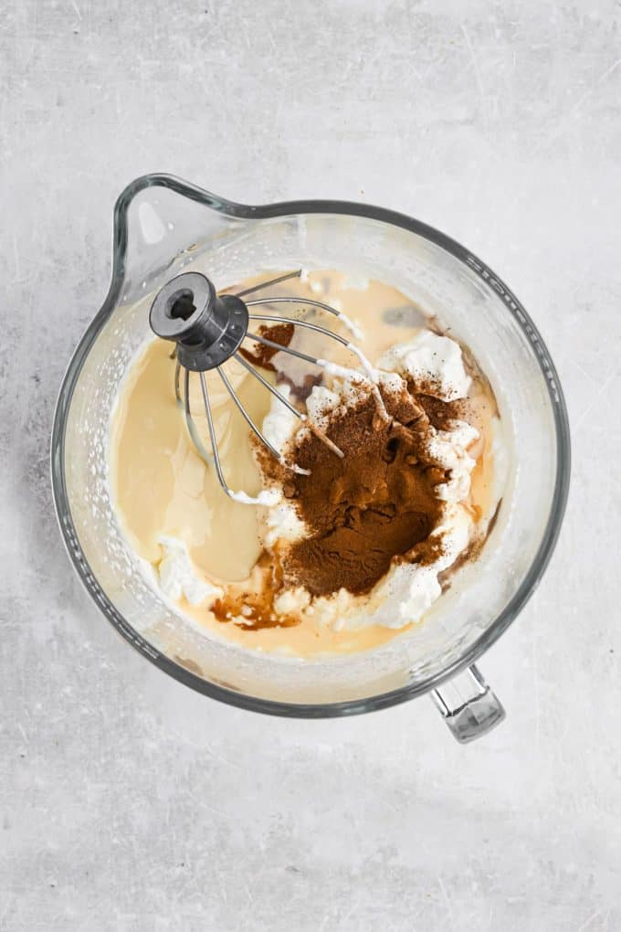 All of the ingredients for eggnog ice cream in a mixing bowl
