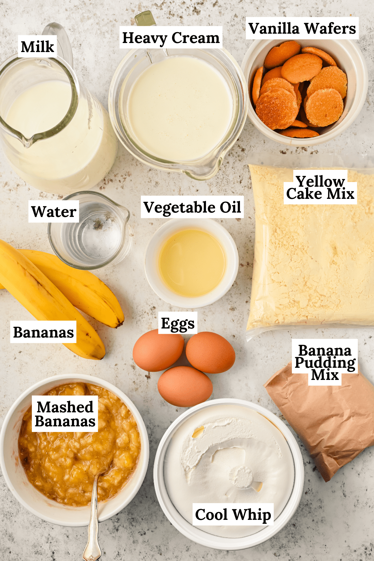 ingredients for banana pudding poke cake arranged on a counter including bananas, 3 eggs, vegetable oil, mashed bananas, cool whip, banana pudding mix and yellow cake mix