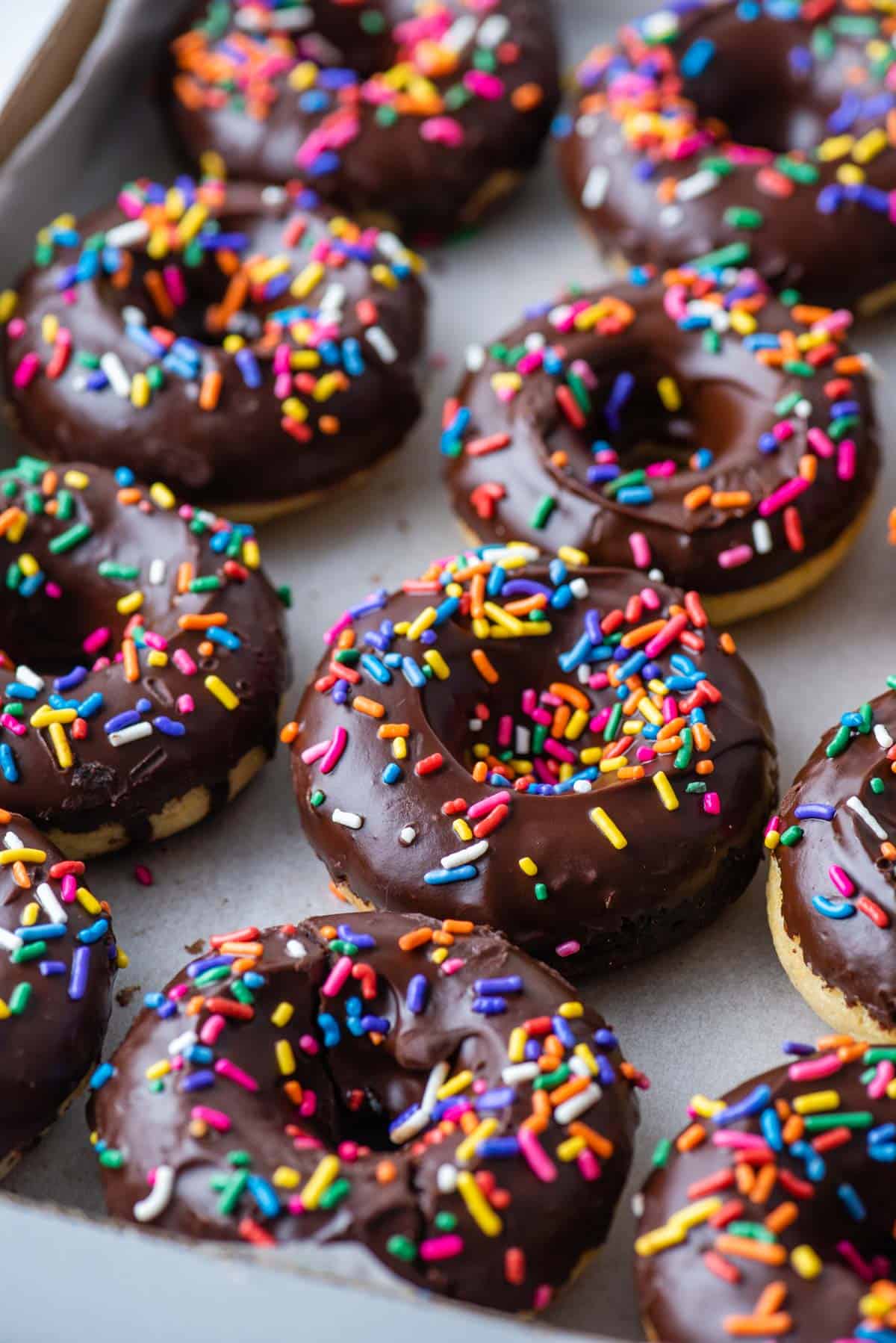 Gluten free chocolate glazed donuts on a baking sheet