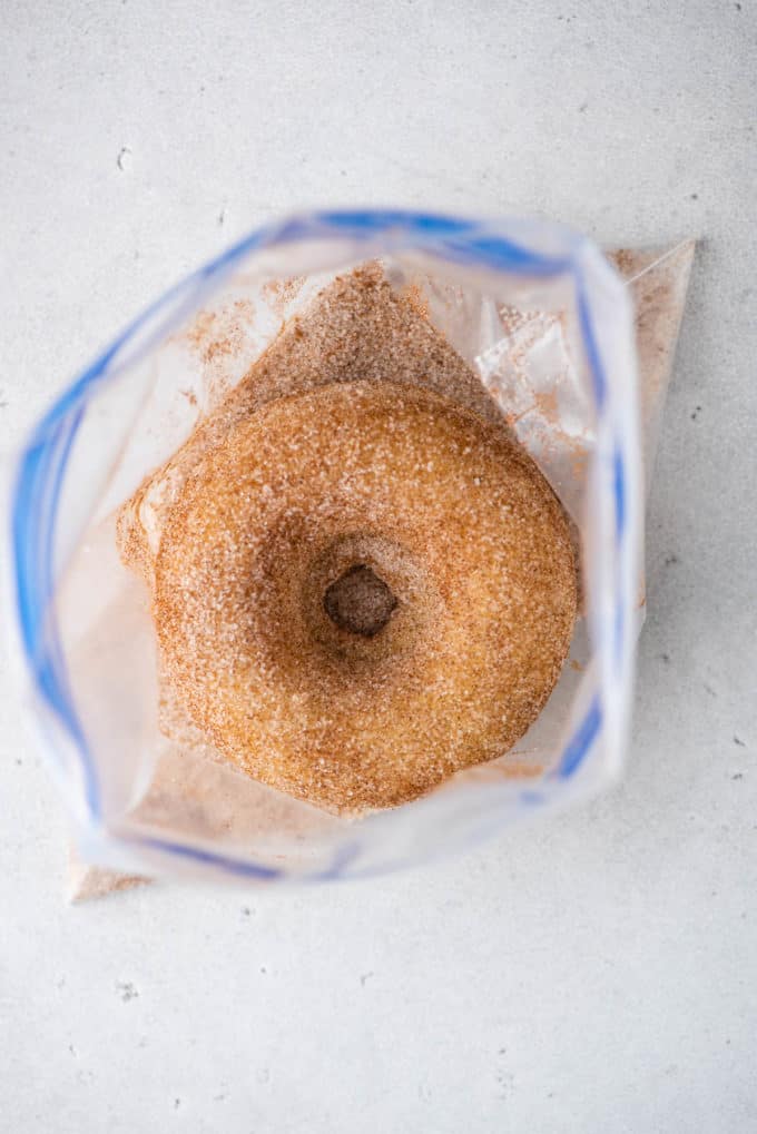 A baked donut in a ziploc bag with cinnamon sugar