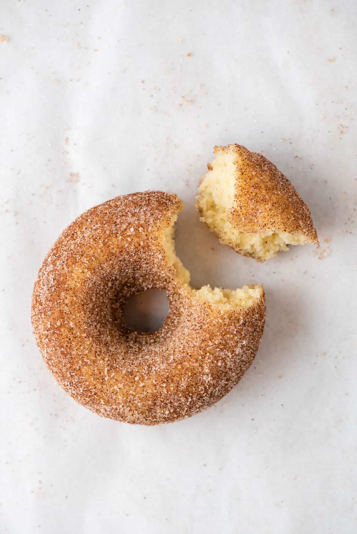 cinnamon sugar donut with bite removed on white background 