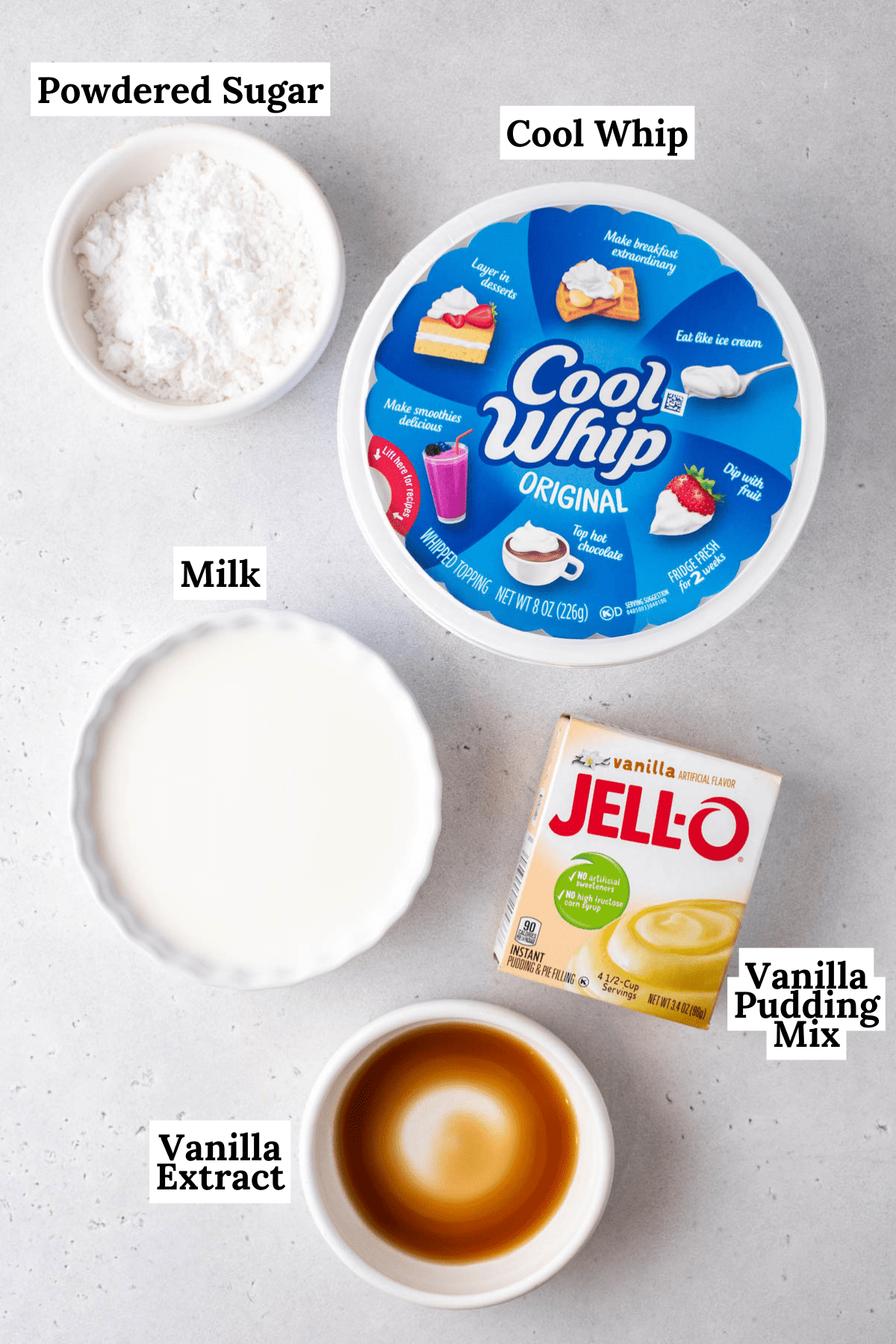 ingredients for cool whip frosting including vanilla extract, powdered sugar, a tub of cool whip, milk, and a box of vanilla pudding mix