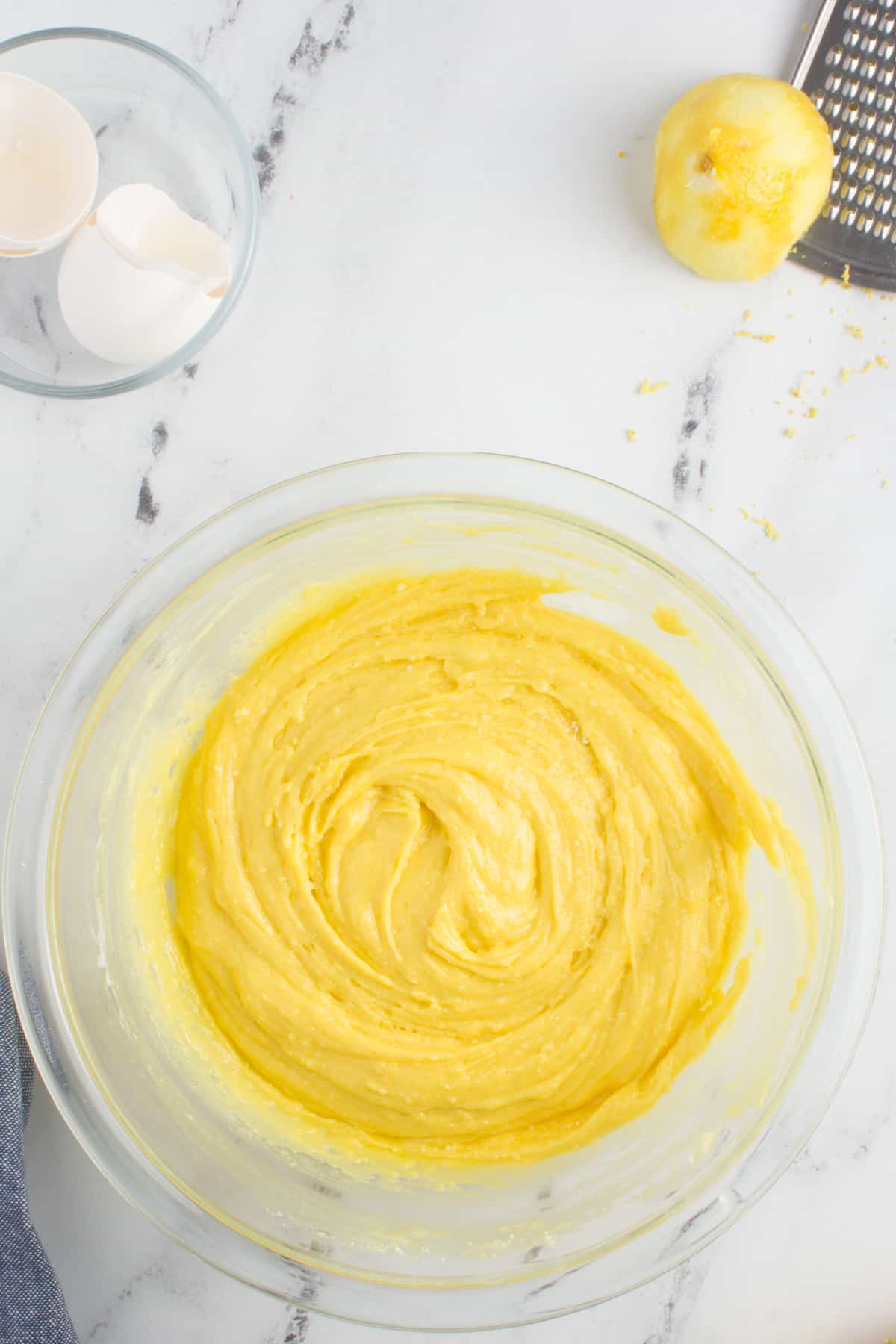 lemon cookie cake mix dough in a glass bowl sitting on a granite counter top