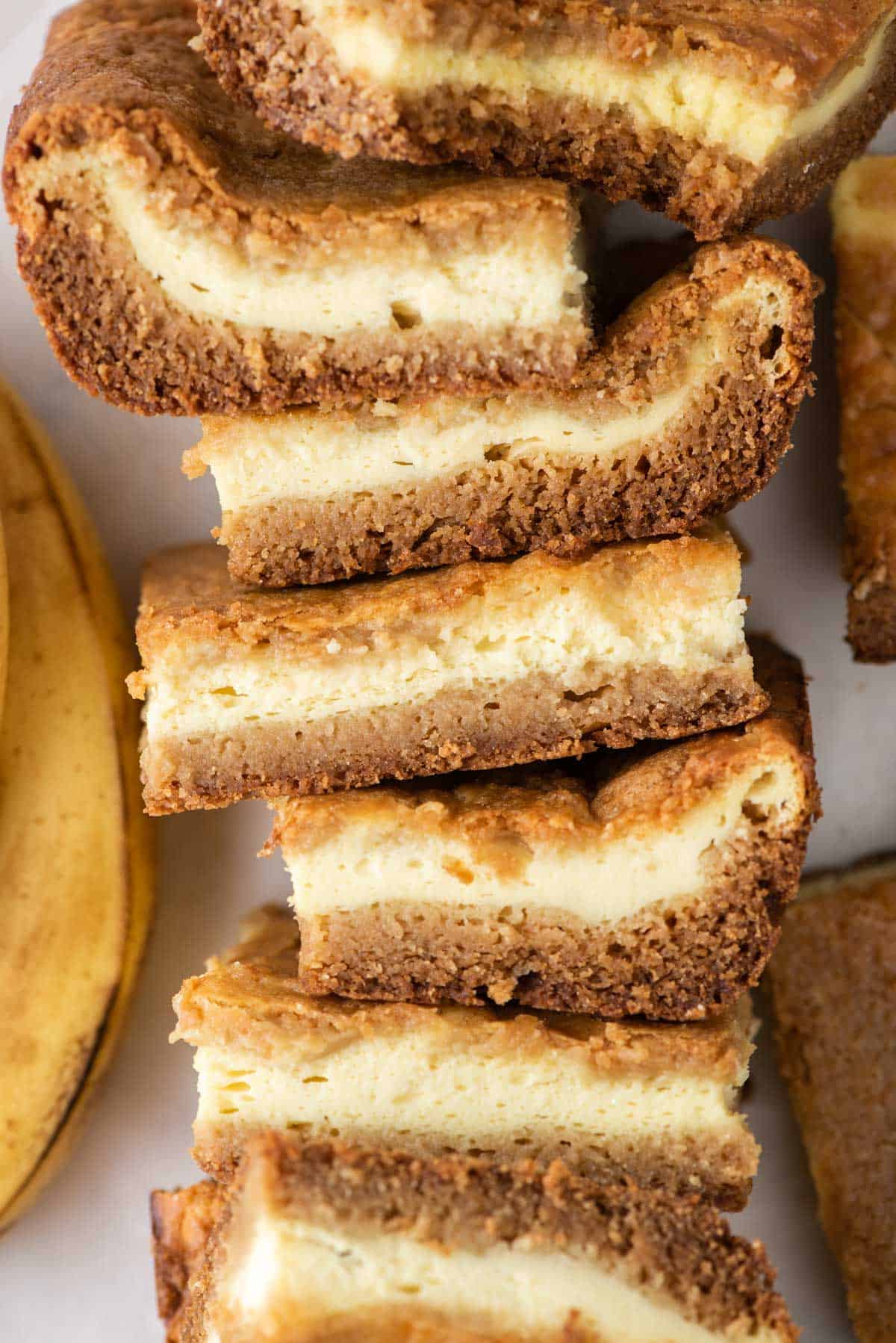 A stack of banana pudding brownies beside a banana