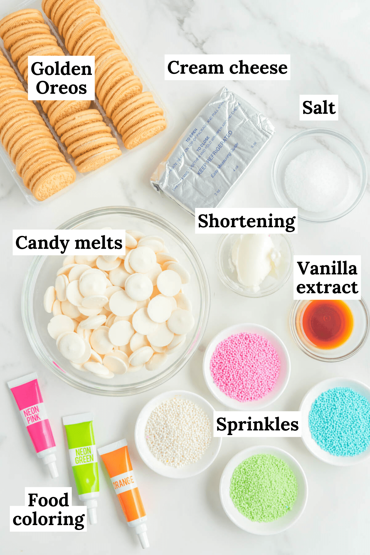 the ingredients for easter egg truffles arranged on a white background, including food coloring, pink, blue, white and green sprinkles, golden oreos, cream cheese, salt, vanilla extract, shortening, and white candy melts
