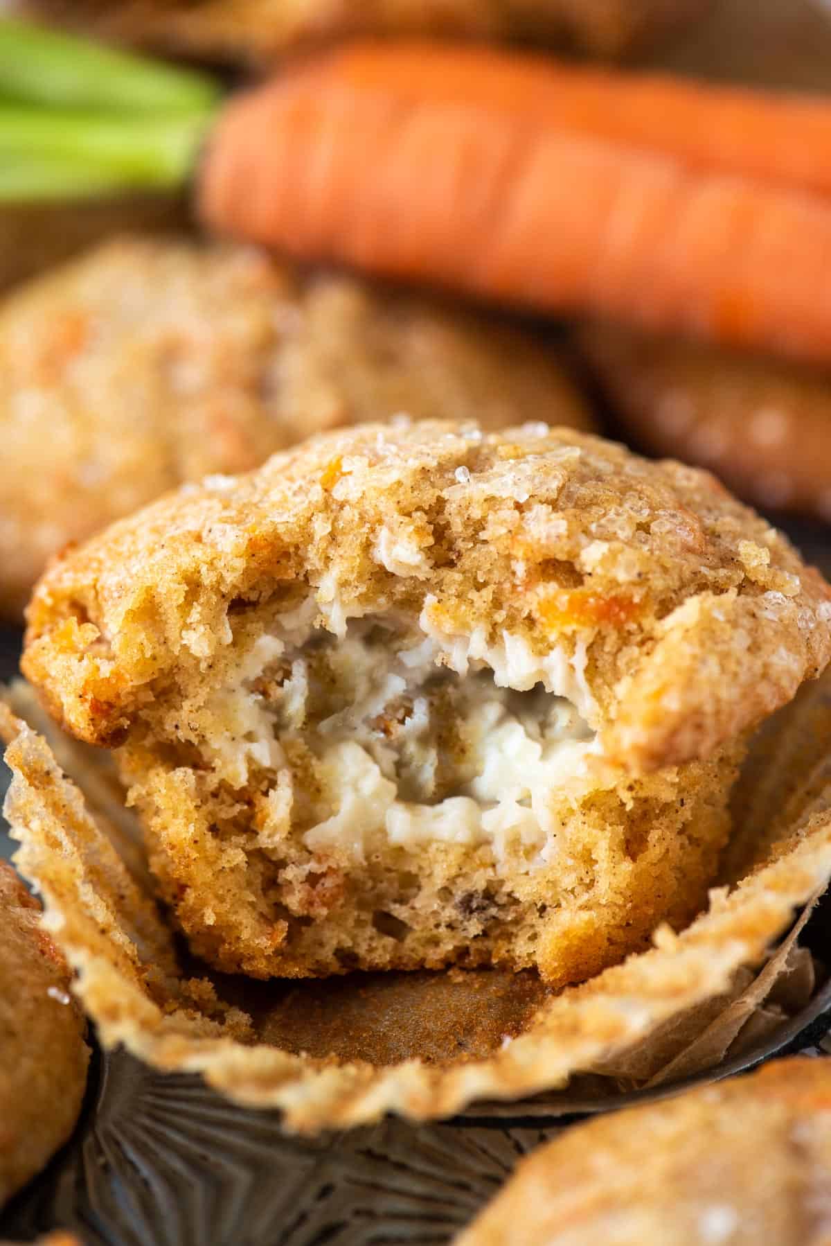 carrot cake muffin with bite removed to show cream cheese filling 