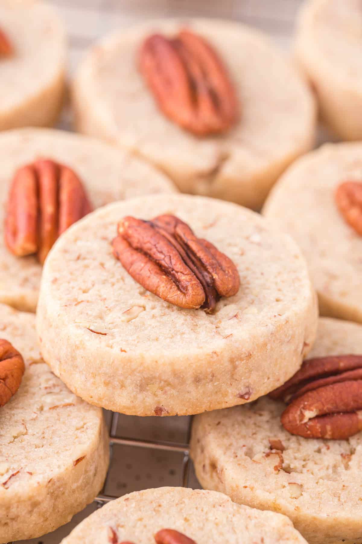 a pile of pecan sandies on top of a wire cooling rack
