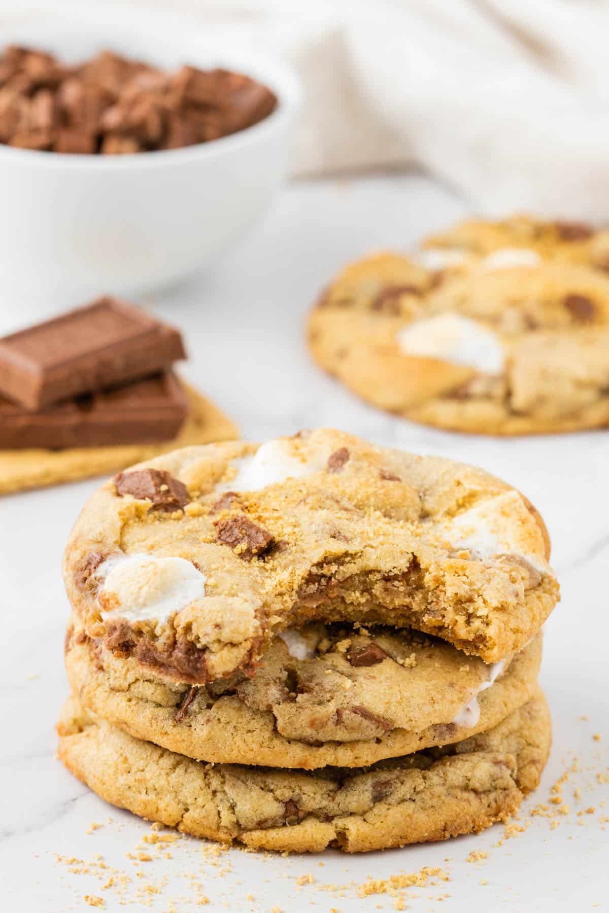 a stack of three smores cookies with a bite out of the top cookie