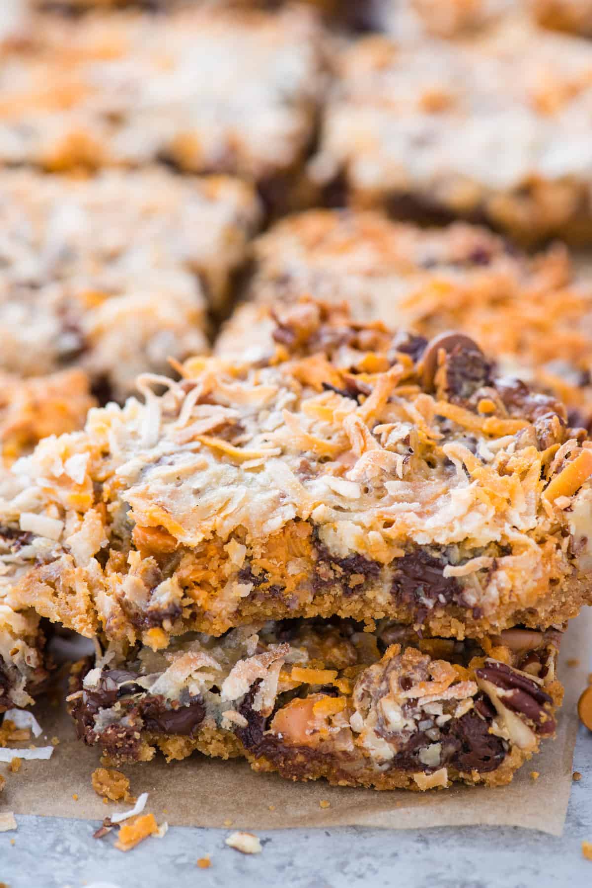 7 layer cookie bars cut into squares on brown parchment paper