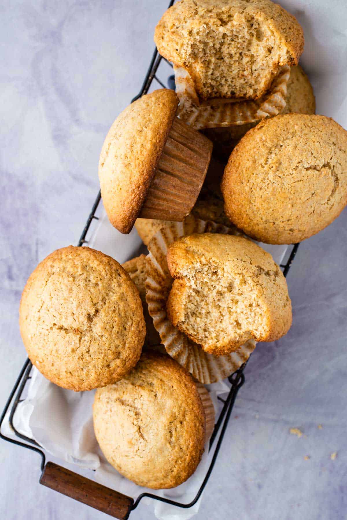 a basket full of bran muffins, some whole and some with a white out