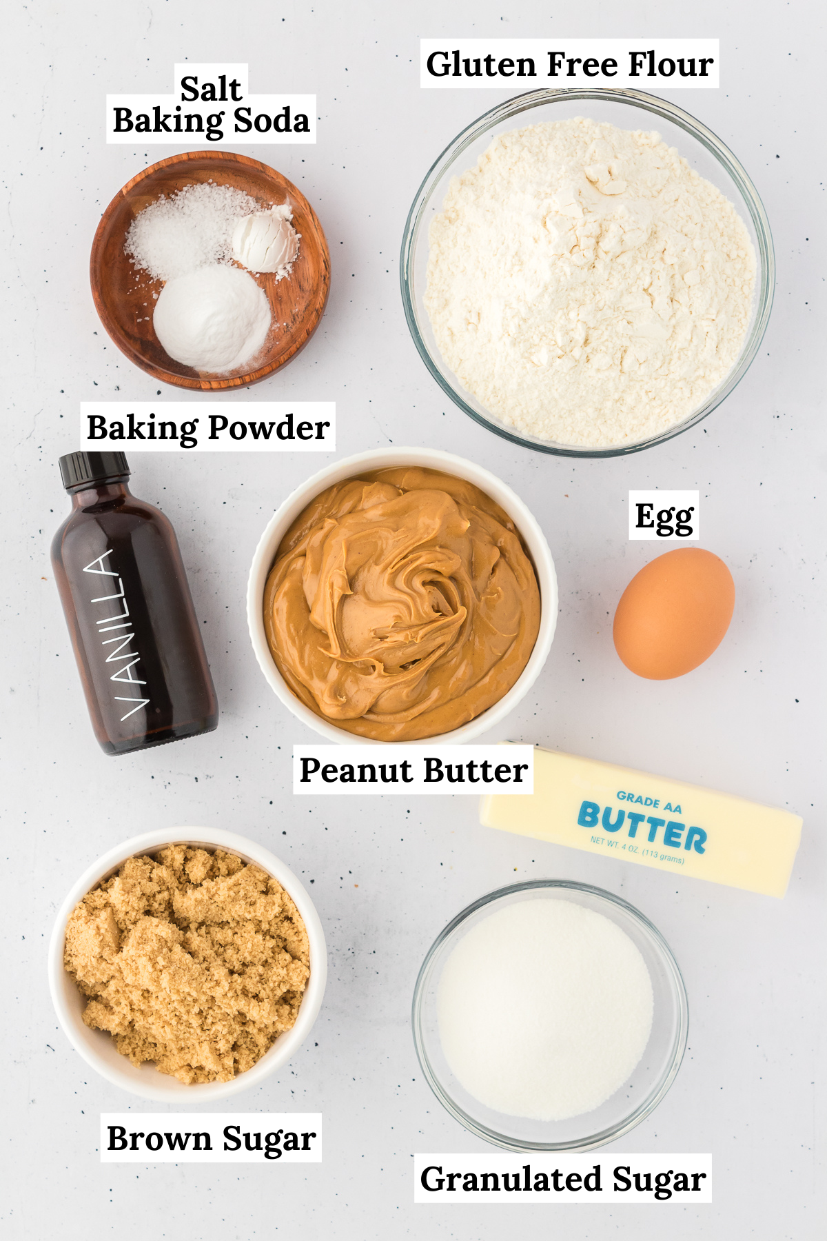 ingredients for gluten free peanut butter cookies including salt, baking soda, gluten free flour, baking powder, vanilla extract, egg, peanut butter, butter, brown sugar and granulated sugar