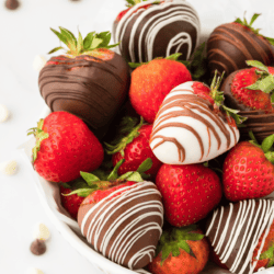 a bowl full of chocolate covered strawberries mixed with fresh, whole strawberries