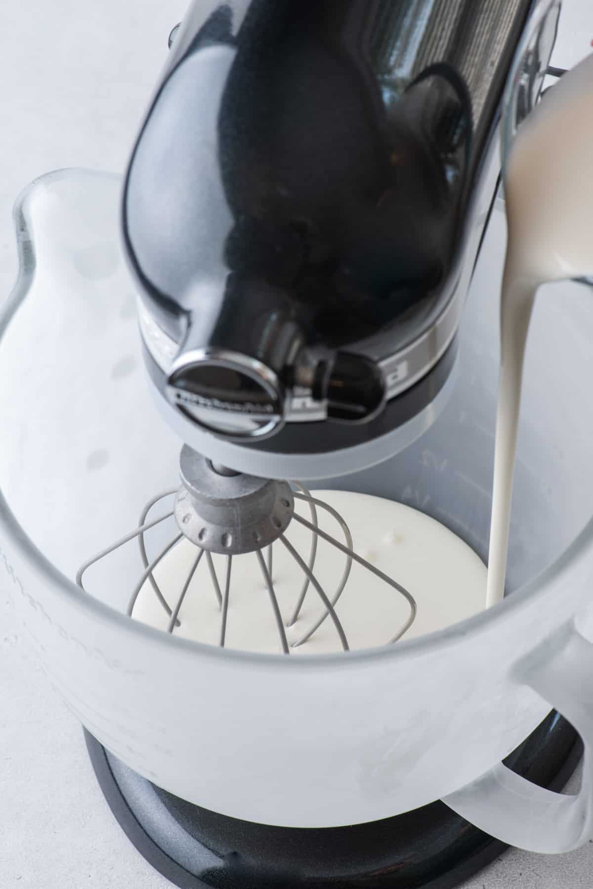heavy whipping cream being poured into an electric mixer