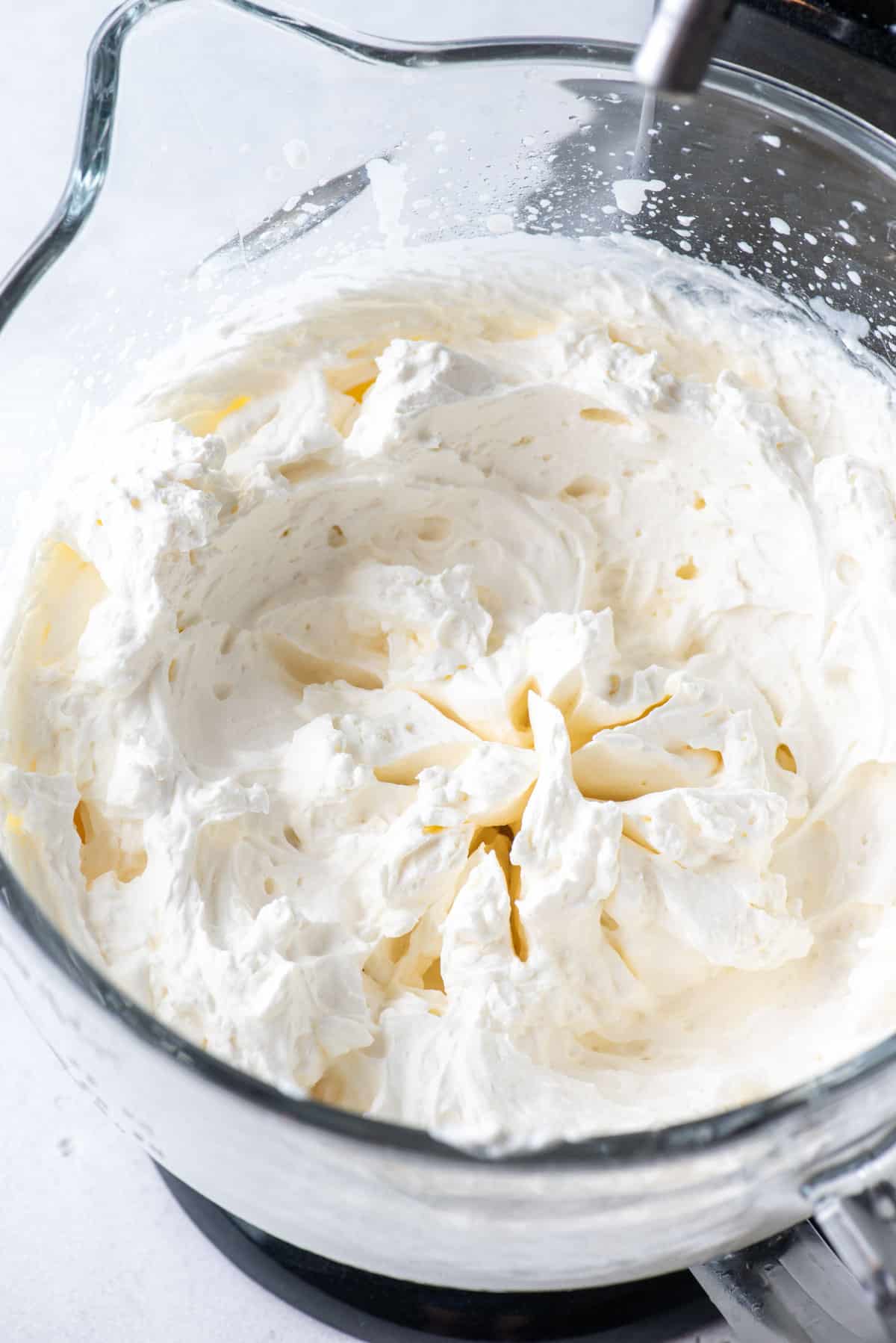 a close up of a glass bowl full of fresh homemade whipped cream