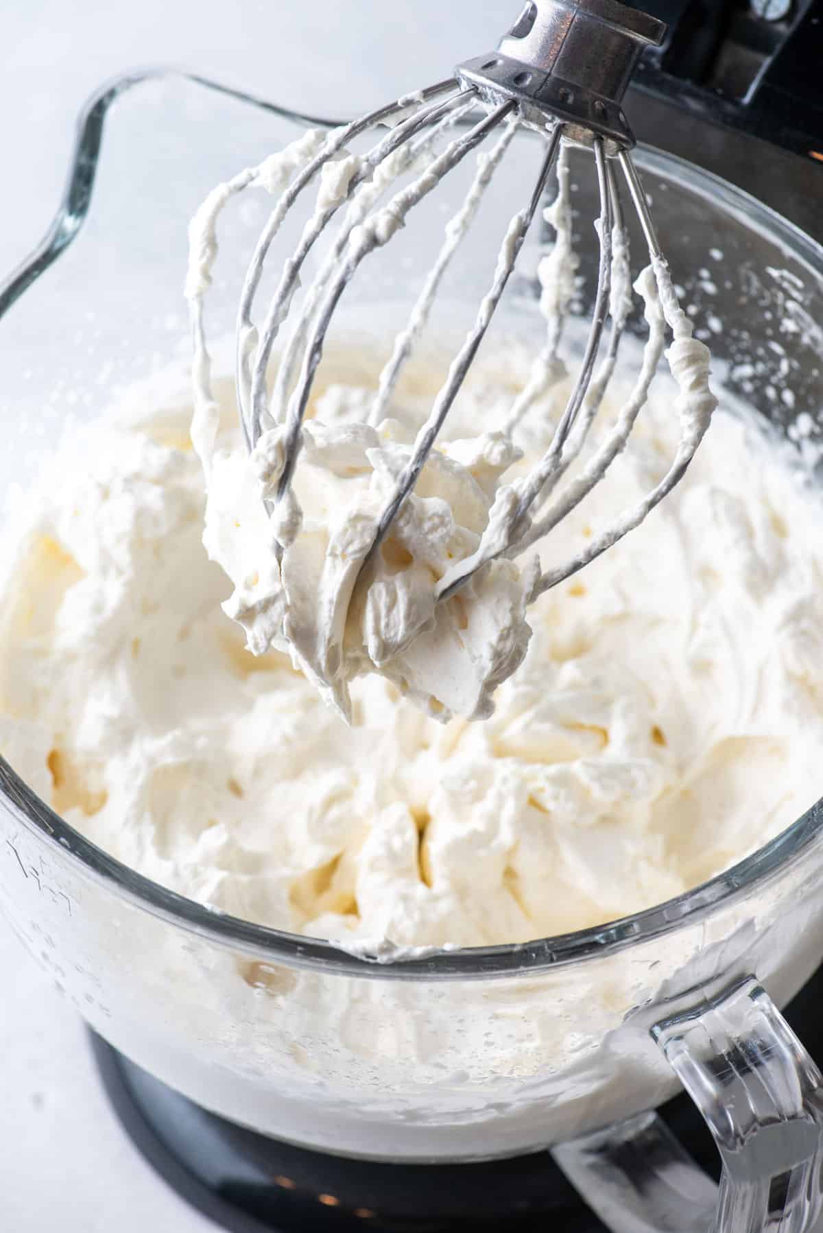 an electric mixer bowl full of fresh whipped cream