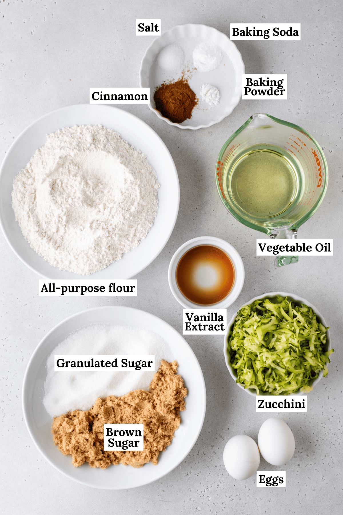 ingredients for zucchini bread including all-purpose flour, baking powder, baking soda, salt, cinnamon, brown sugar, granulated sugar, vegetable oil, eggs, vanilla and grated zucchini