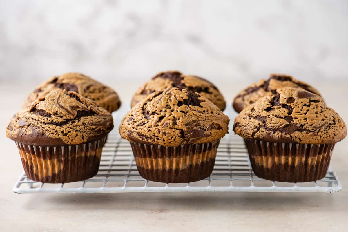 chocolate peanut butter muffins lined up on a cooling rack