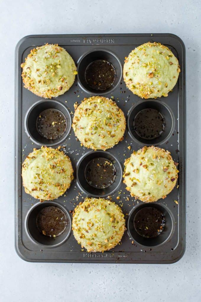 freshly baked pistachio muffins in every other hole of a muffin tin