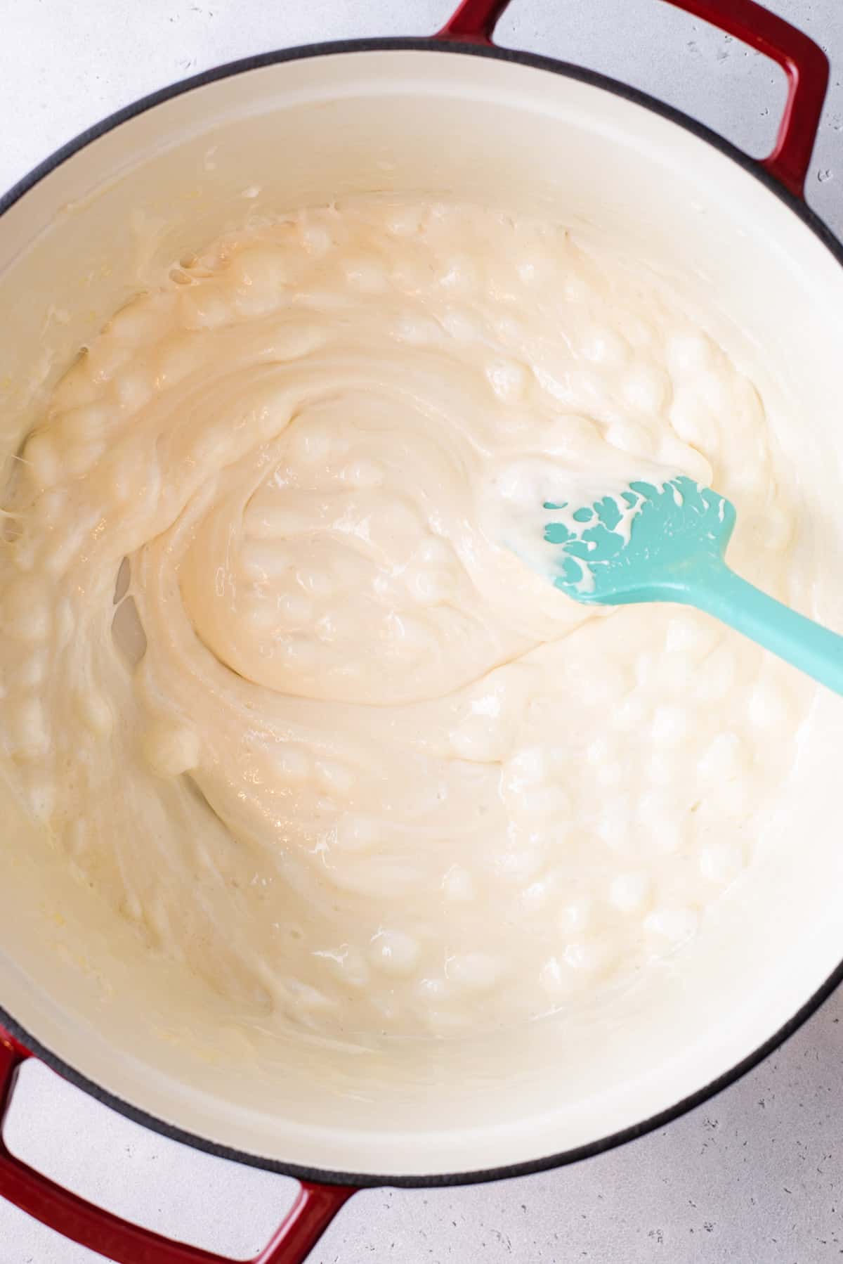 mini marshmallows and butter mixed together and melted in a pot with a teal spatula