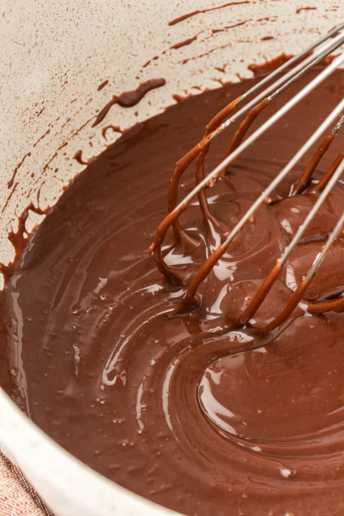 close up of chocolate frosting being whisked in a saucepan