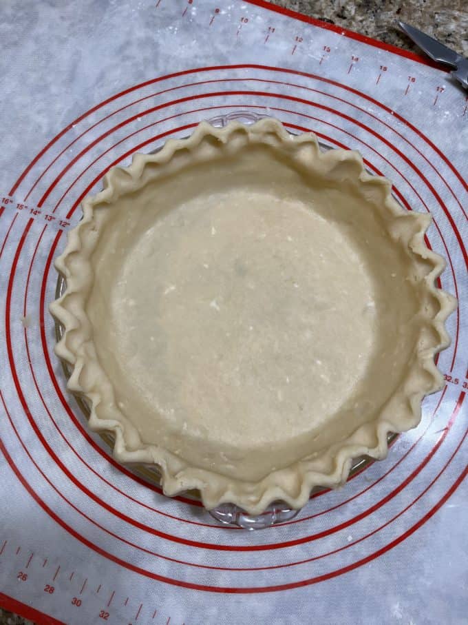 pie crust in a glass pie dish on top of a pie mat