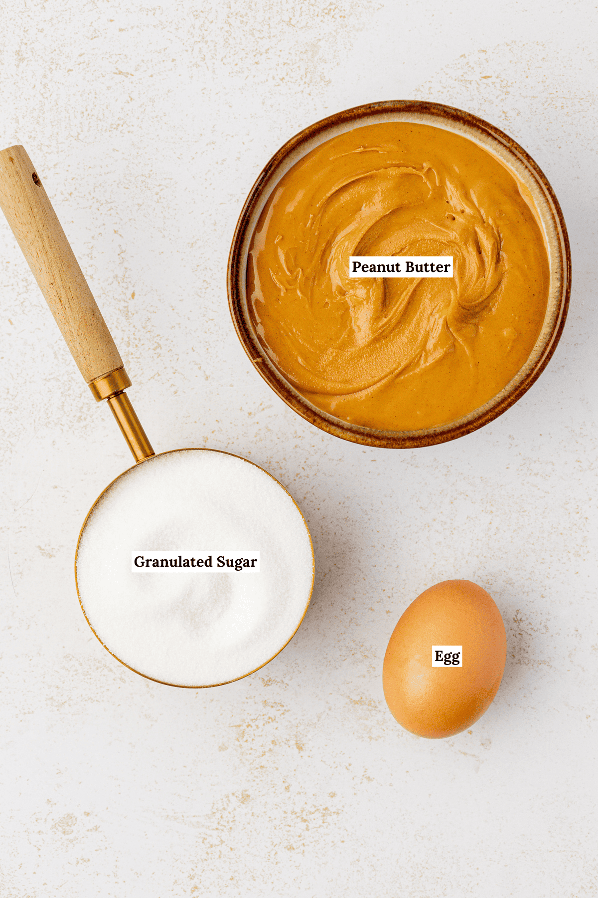 overhead view of the ingredients for 3-Ingredient Peanut Butter Cookies including peanut butter, granulated sugar and one large egg