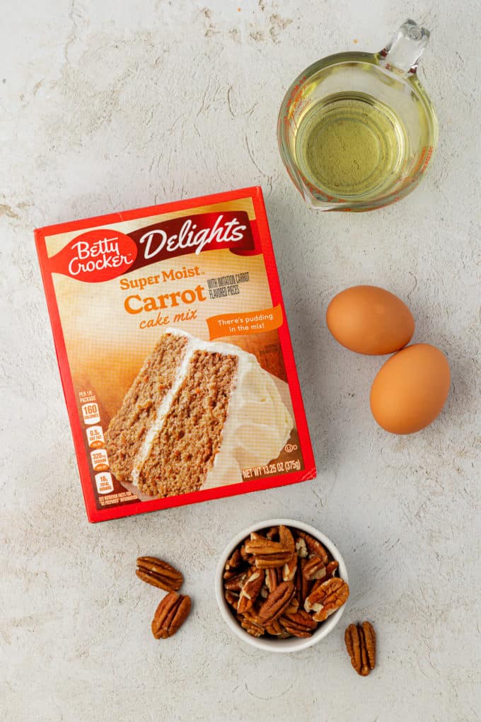 ingredients for carrot cake cake mixed cookies including carrot cake mix, two eggs, pecans and vegetable oil
