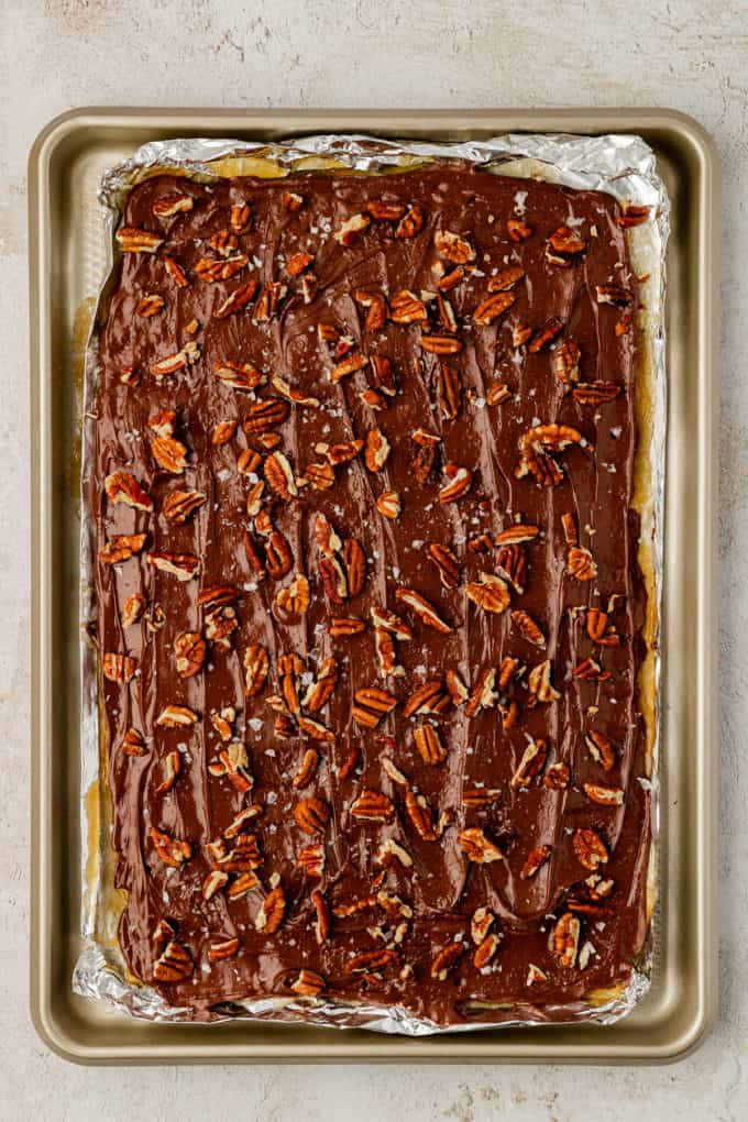 a full sheet pan of christmas crack candy covered in pecans and sea salt