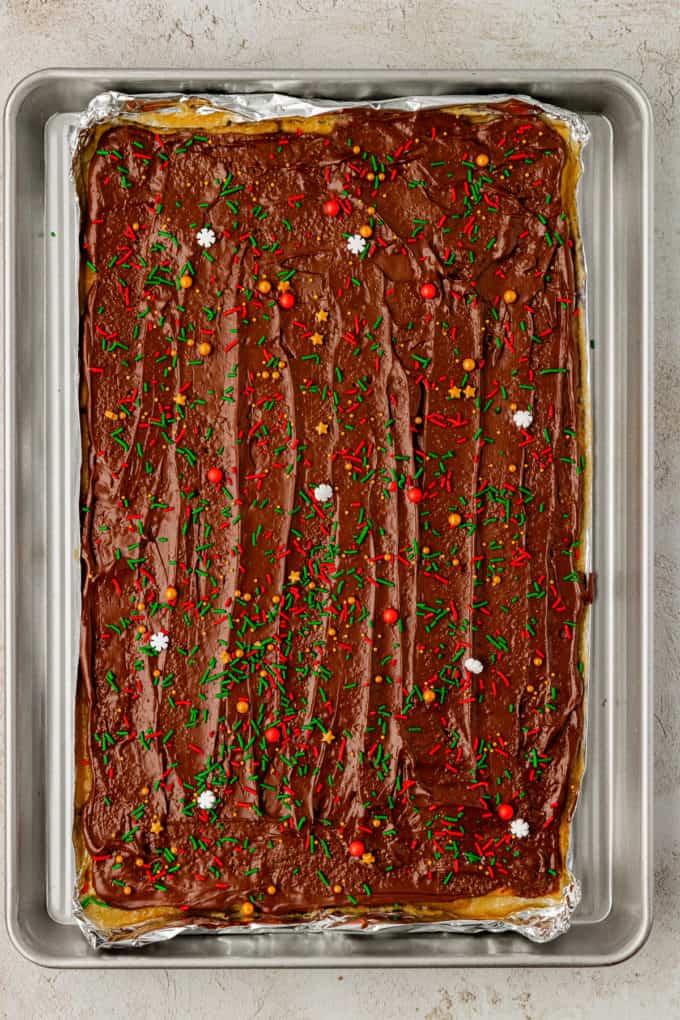 a full sheet pan of christmas crack candy covered in holiday sprinkles