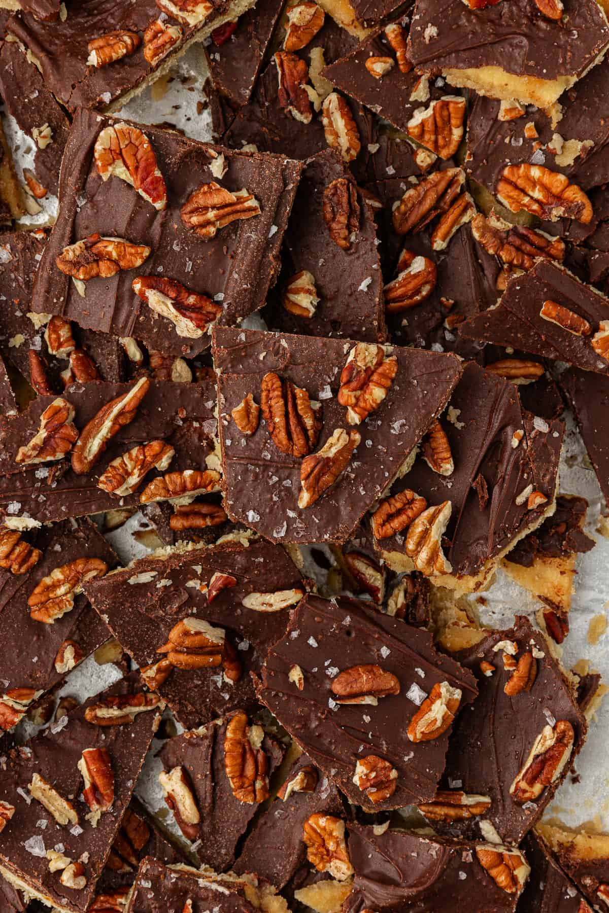 close up of a pile of christmas crack candy with pecans and sea salt on top