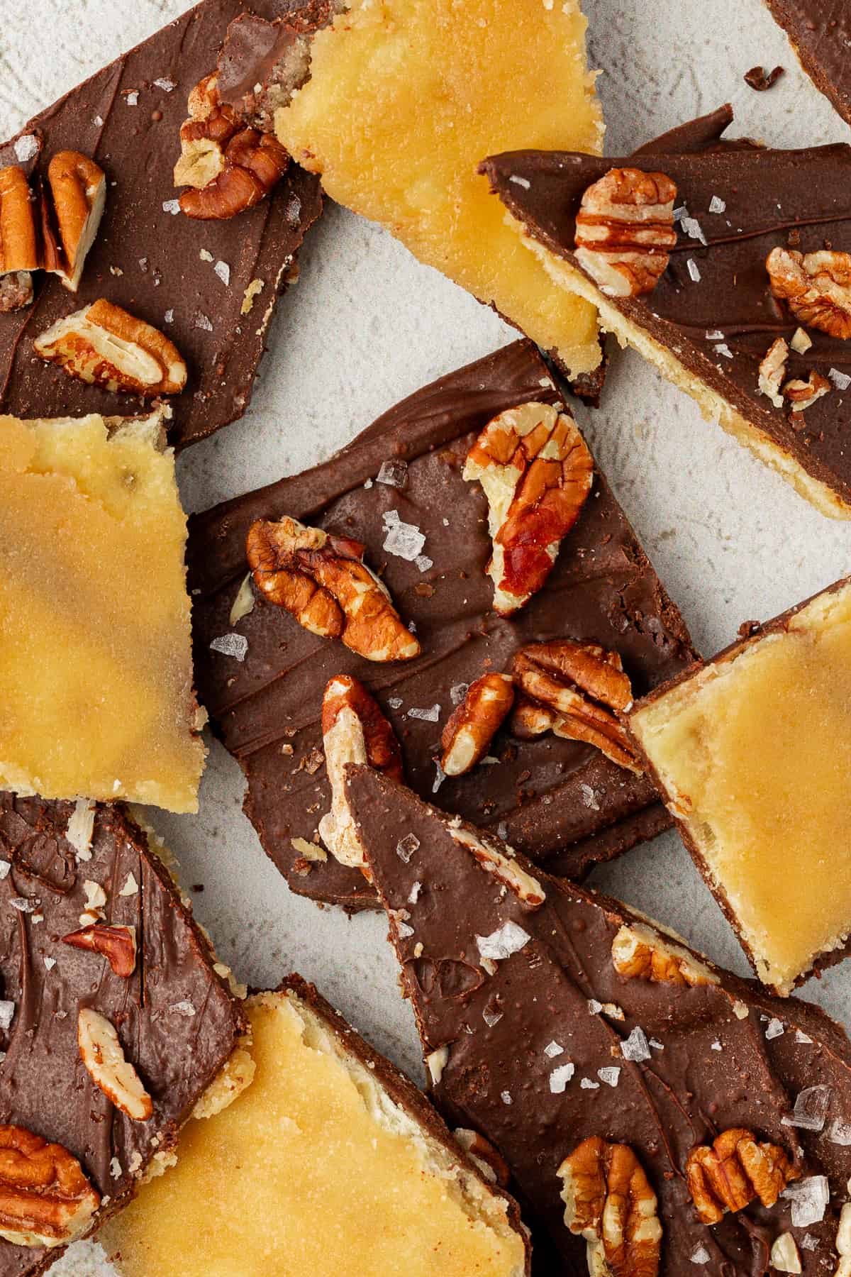 Christmas crack candy with pecans and sea salt arranged around each other, some upside down