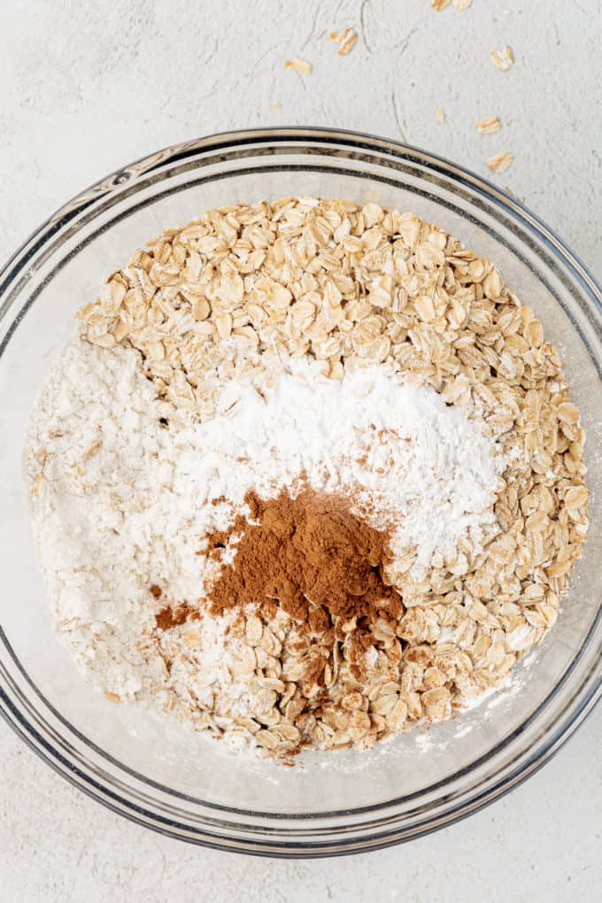 dry ingredients for oatmeal cookies and oats in a clear glass bowl