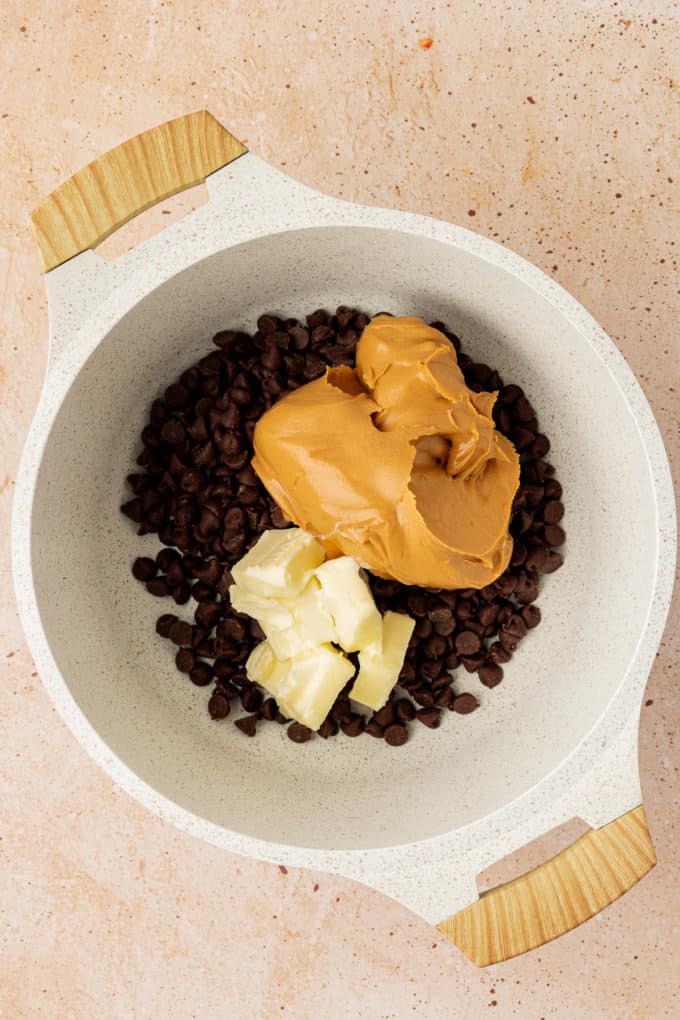chocolate chips, peanut butter and cubes of butter in a white pot