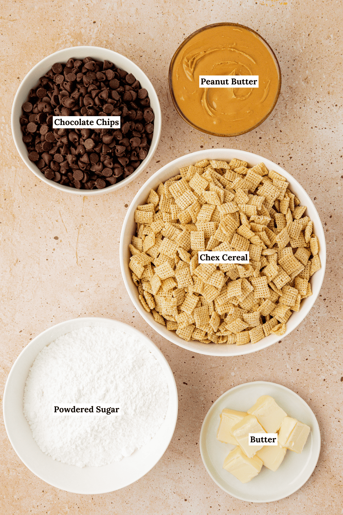 overhead view of puppy chow ingredients including chex cereal, powdered sugar, chocolate chips, peanut butter and butter
