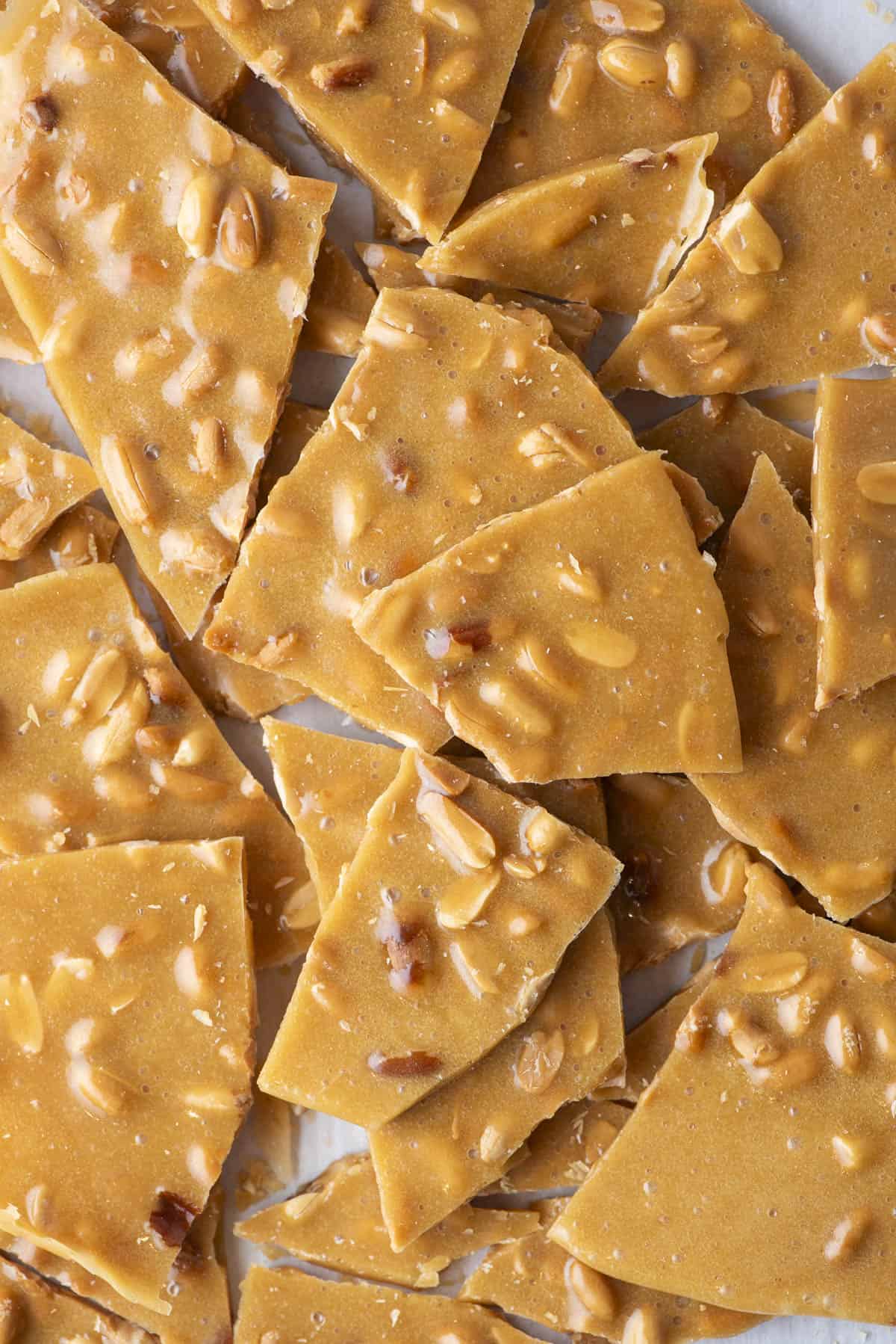 close up of a pile of peanut brittle pieces on a countertop surface
