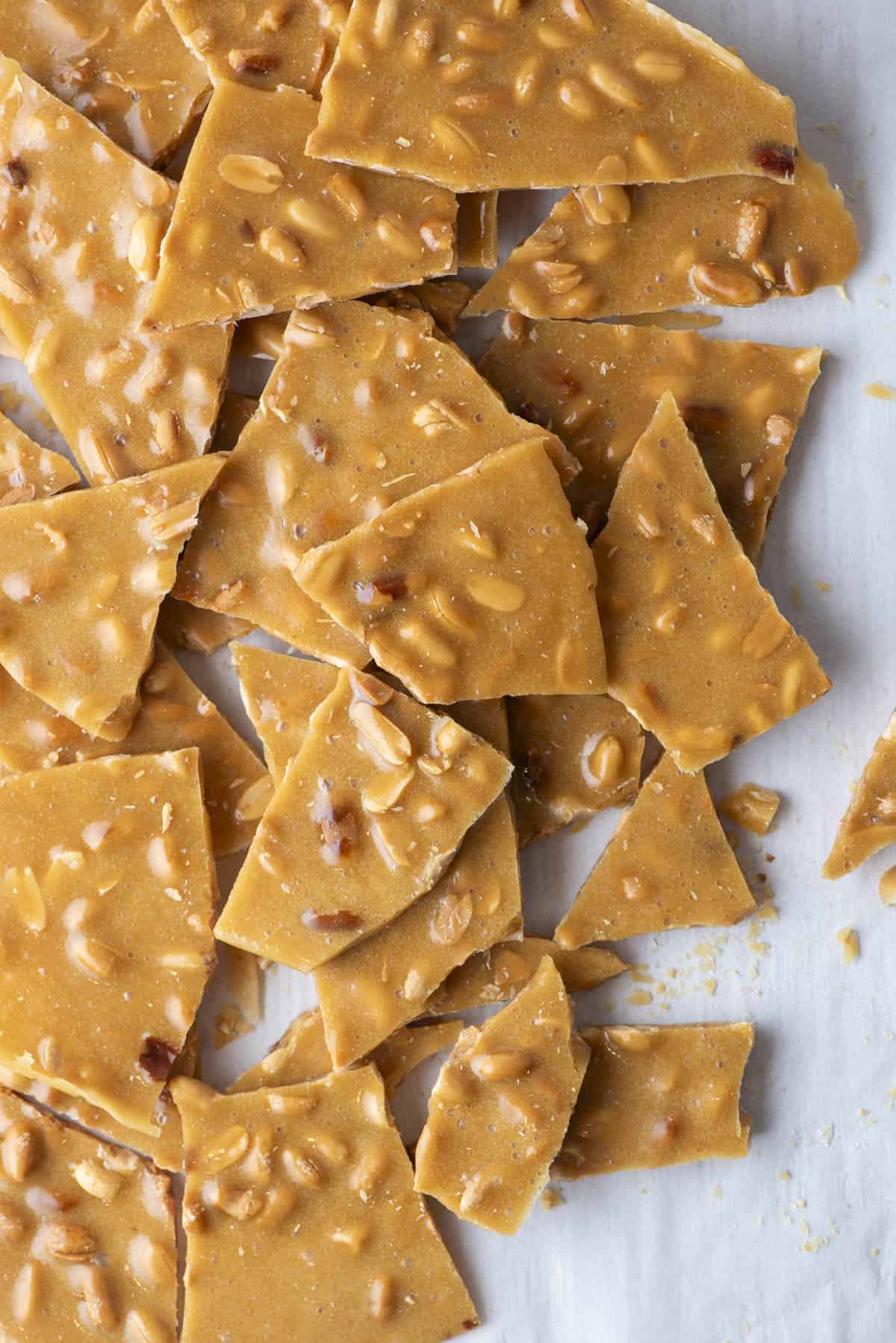 peanut brittle pieces piled up on a countertop surface
