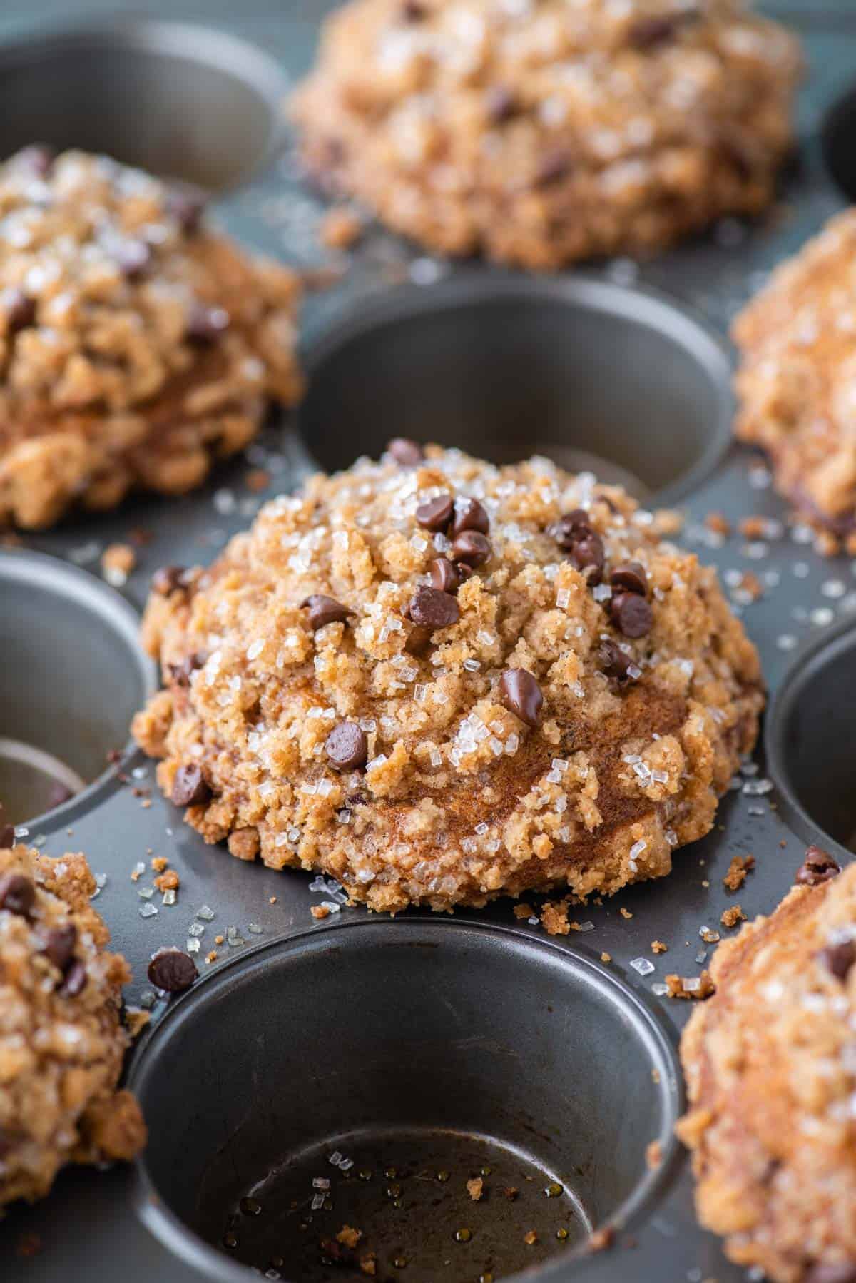 banana chocolate chip muffins with domed tops in every other hole of a muffin pan