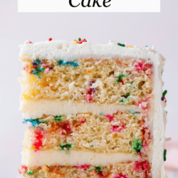 a slice of layered funfetti cake with 3 layers of cake and two layers of frosting, with rainbow sprinkles all around