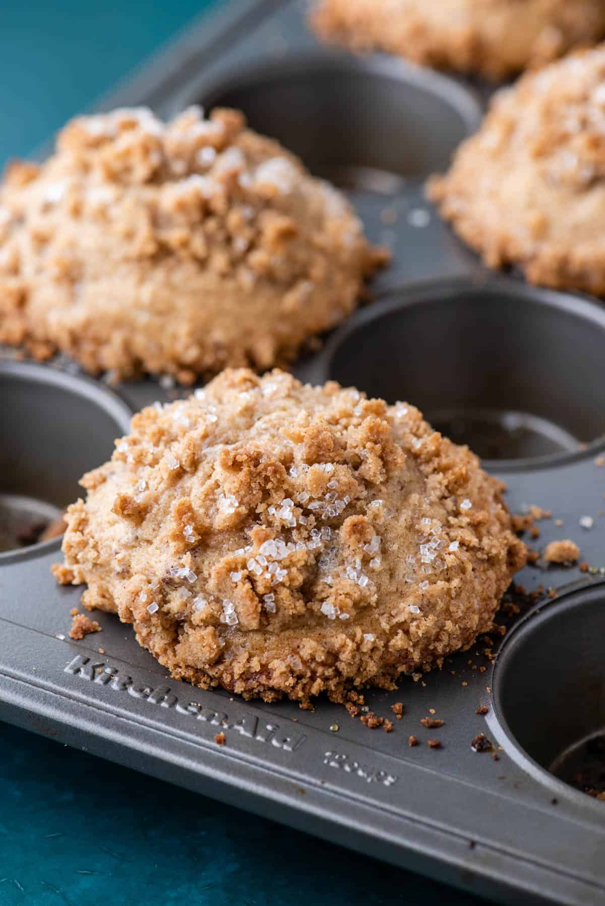 a muffin pan with maple pecan muffins in it, filling every other hole