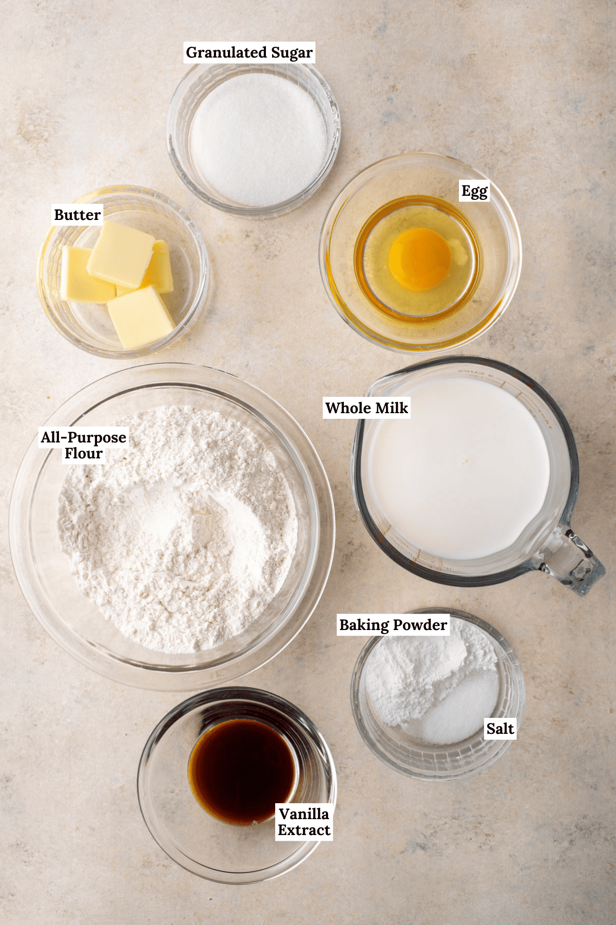 ingredients for pancakes including all-purpose flour, granulated sugar, baking powder, salt, milk, egg, unsalted butter, and vanilla extract