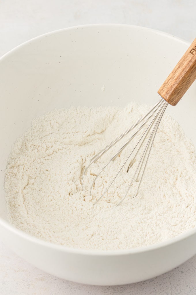 dry ingredients for buttermilk pancakes in a white bowl with a wire whisk