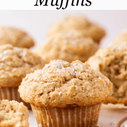 oatmeal muffins on a light pink surface with oats sprinkled around