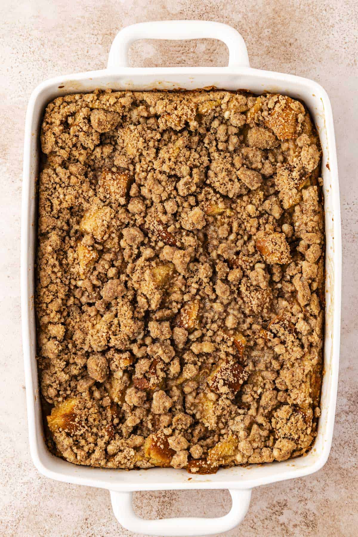 over head view of a white baking dish full of french toast casserole topped with crumb topping