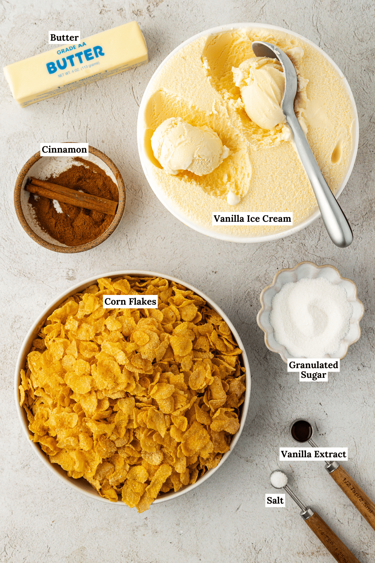 over head view of the ingredients for fried ice cream including vanilla ice cream, butter, cinnamon, corn flakes, granulated sugar, vanilla extract, and salt