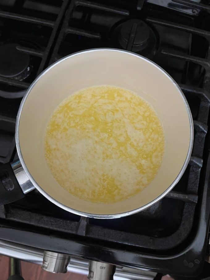 melted butter cooking in a small pot on a stovetop