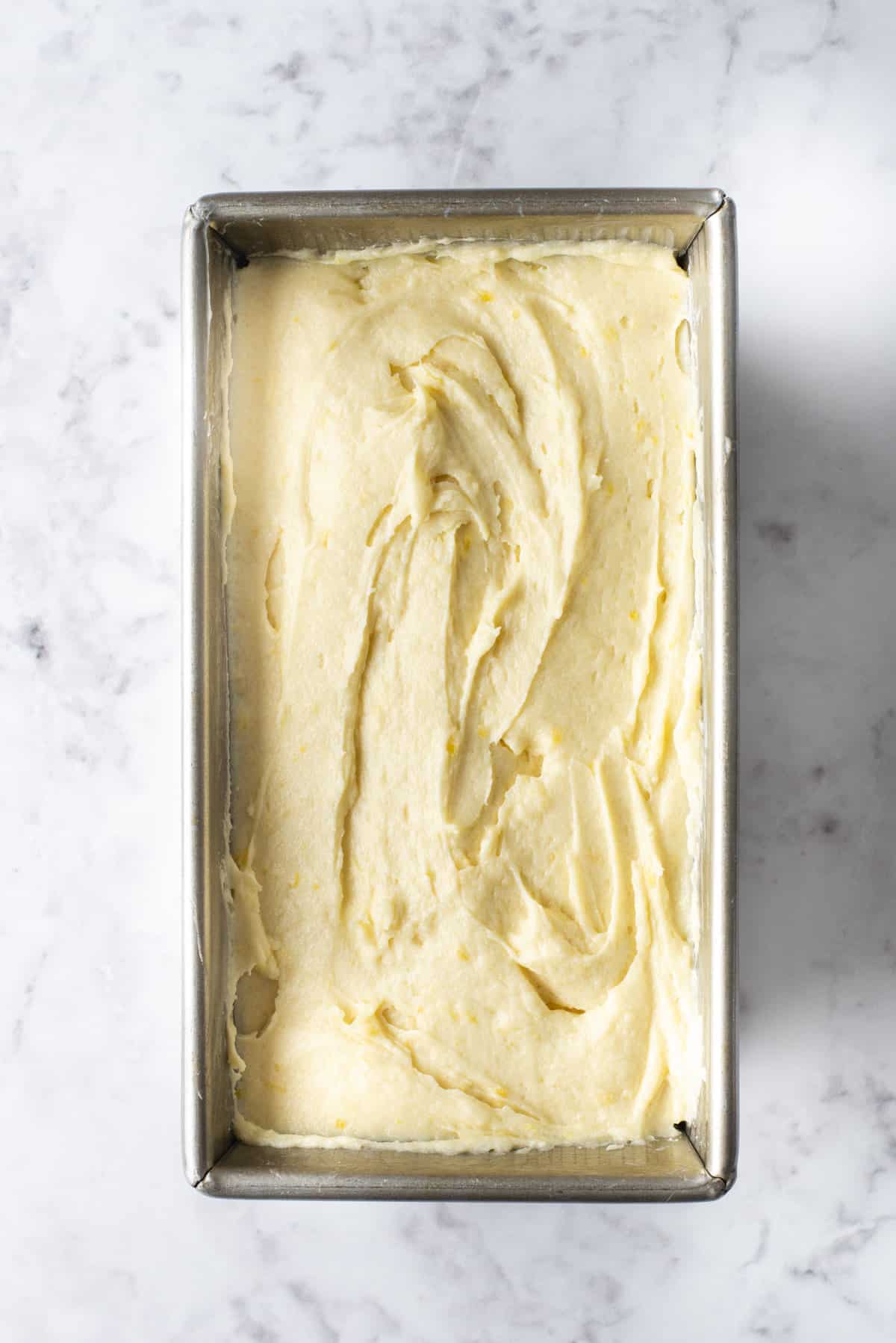 lemon pound cake batter in a loaf pan on a countertop